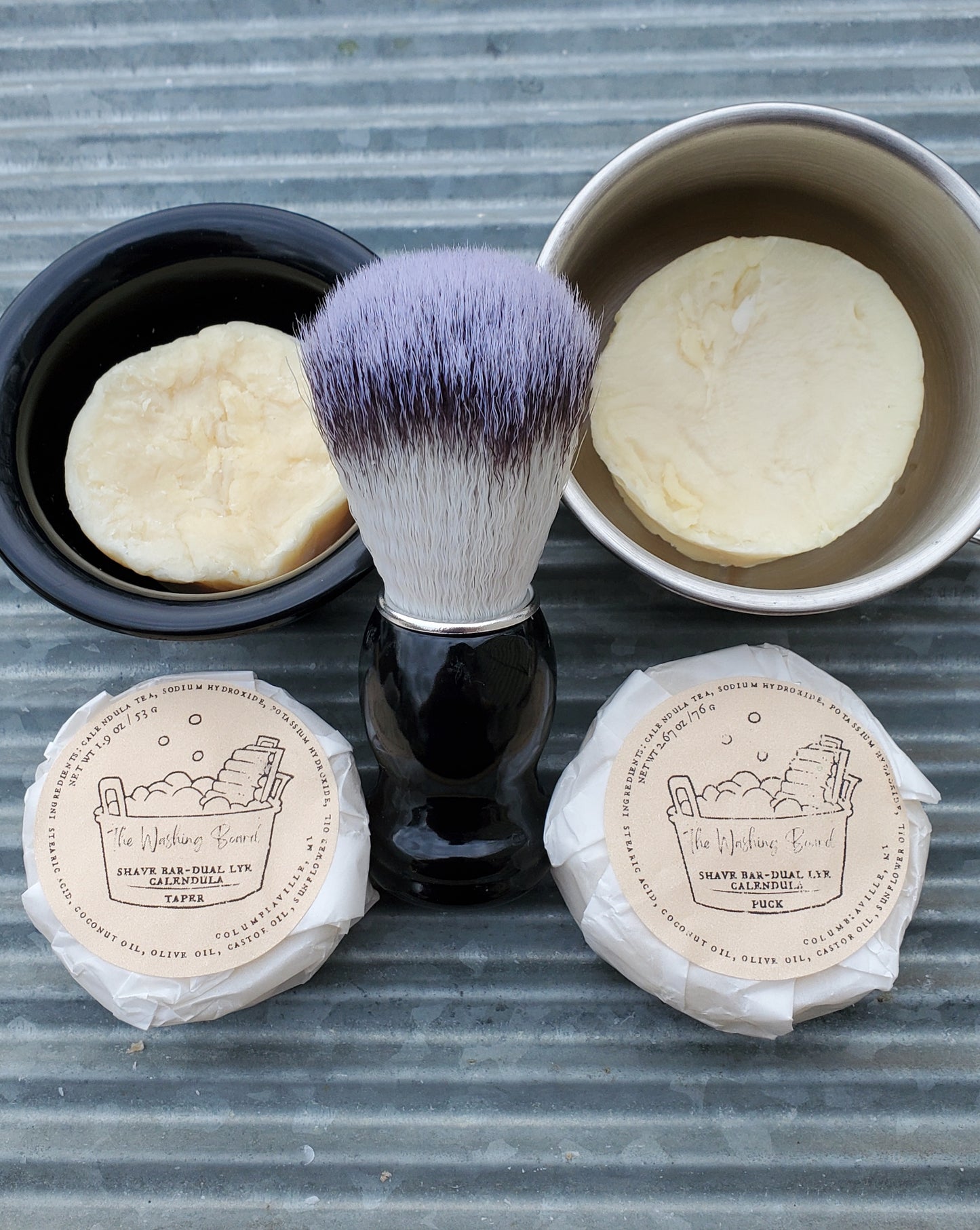 Dual Lye Shave Soaps, "Naked" Taper in the black bowl, "naked" Puck in the stainless steel cup, a Shave Brush, a wrapped taper and a wrapped puck.