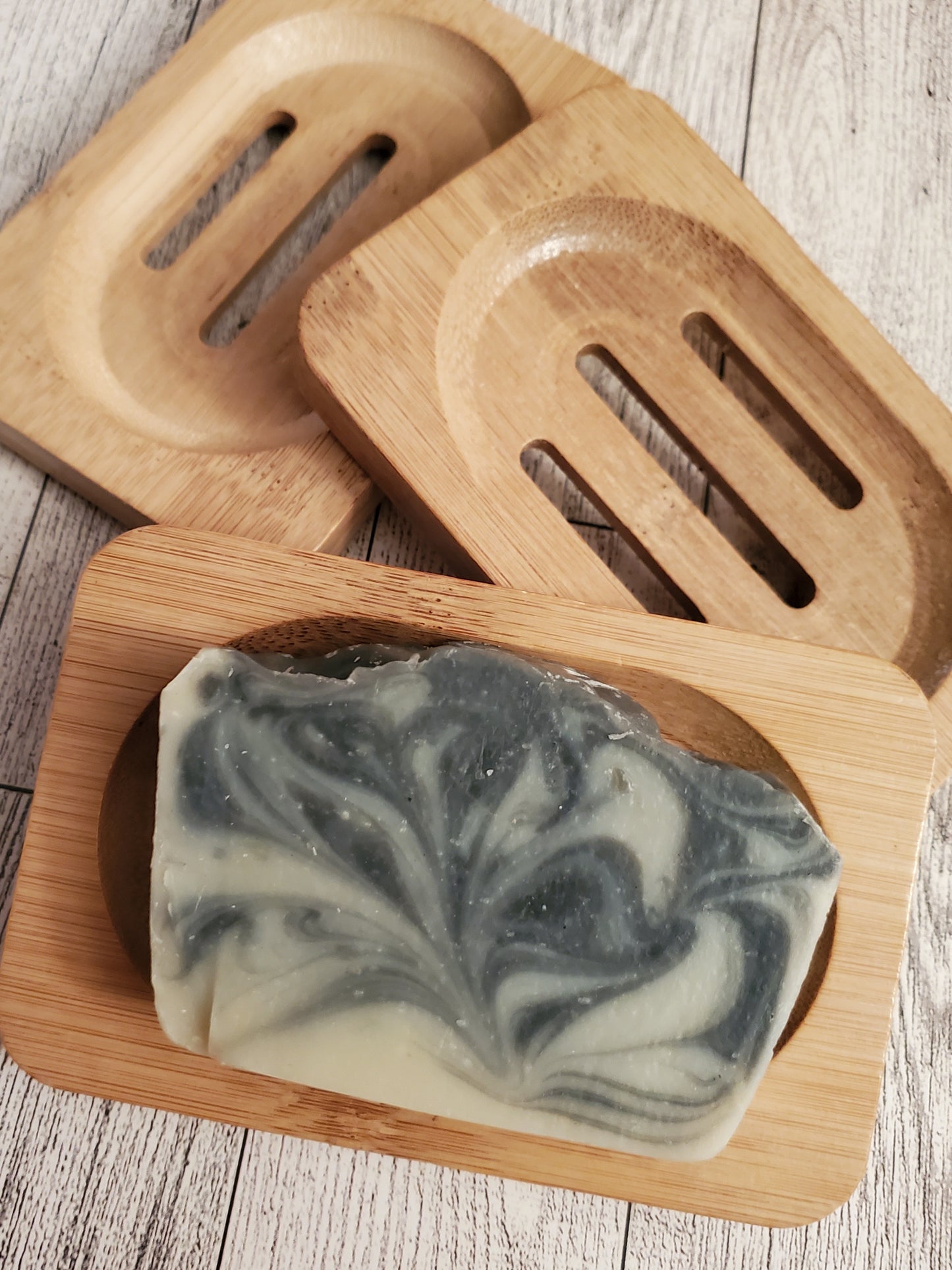 Cucumber Charcoal Dream shown on medium color wooden soap dish.