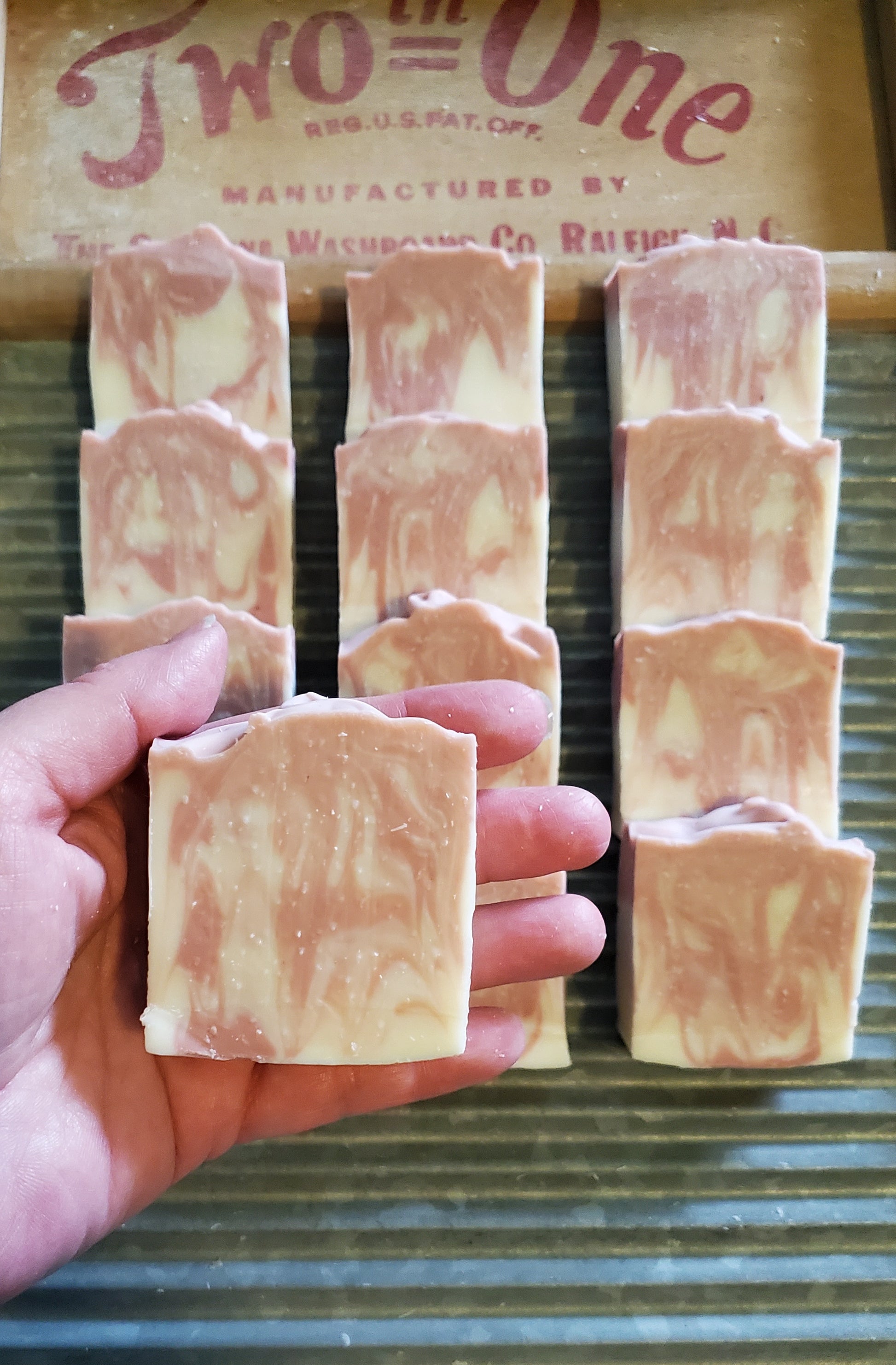 Just Plain Soap pink edition, tall and narrow, bar,  shown in a woman's hand. 