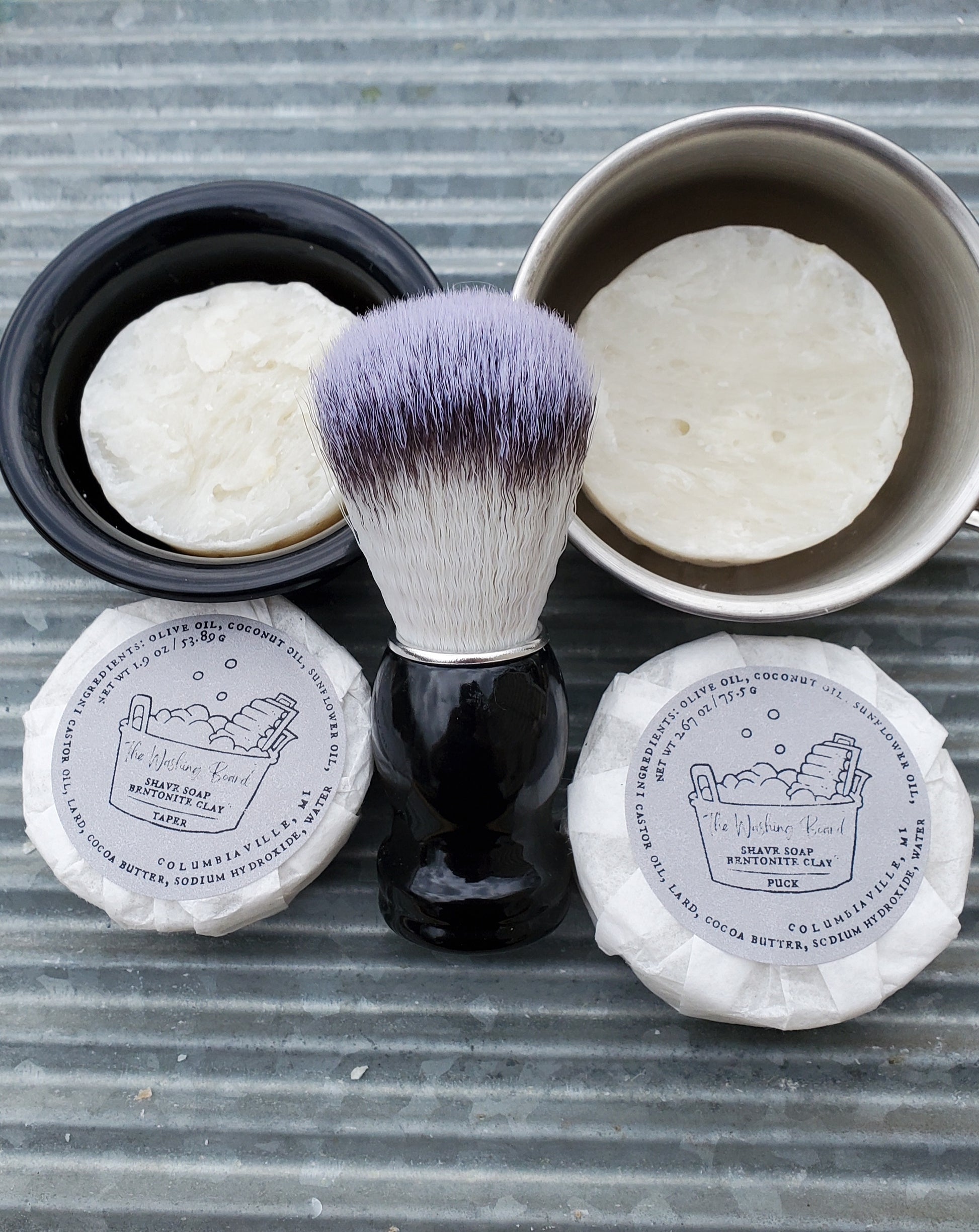 Bentonite Clay Shave Soaps,  "Naked" Taper in the black bowl, "naked" Puck in the stainless steel cup,  a Shave Brush, a wrapped taper and a wrapped puck.