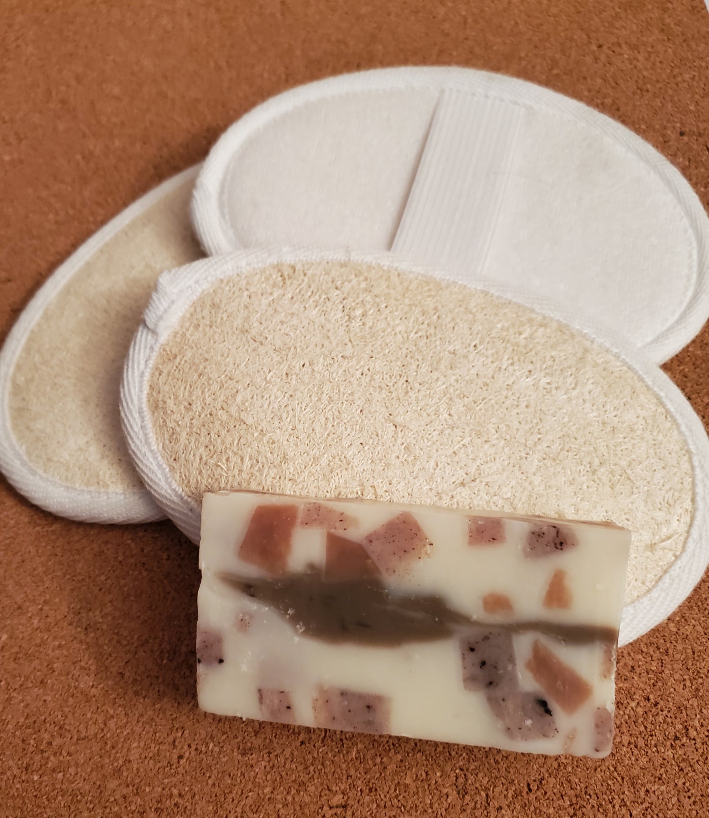 3 Scrubby Luffa Pads shown together with a bar of Calico All in One Shampoo and Body soap.