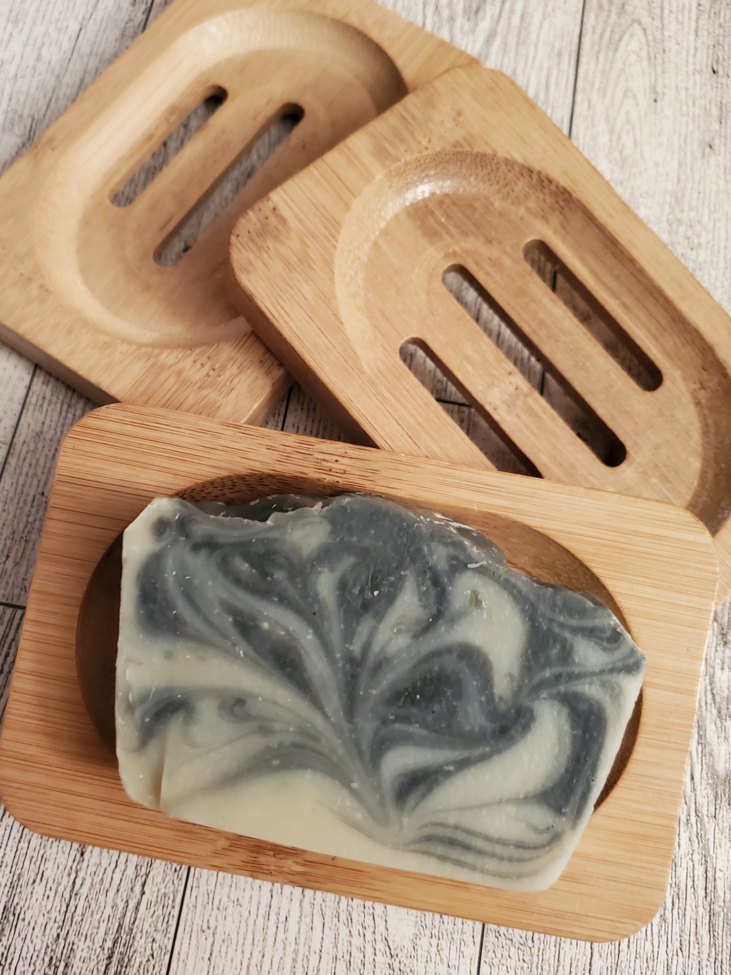 Cucumber Charcoal Dream shown on medium color wooden soap dish. 